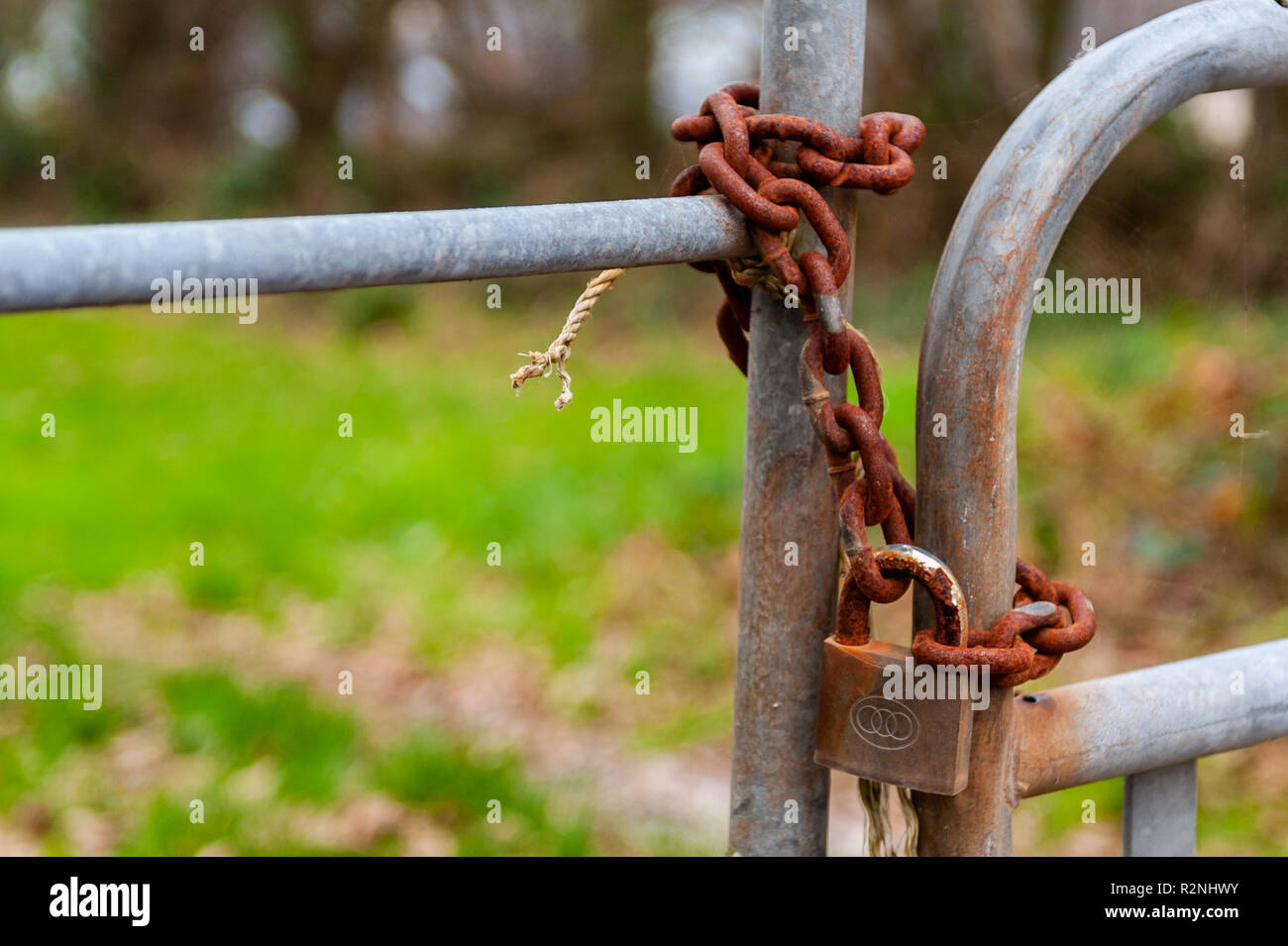 Candado y portones encadenados con la cadena oxidada en Irlanda. Foto de stock