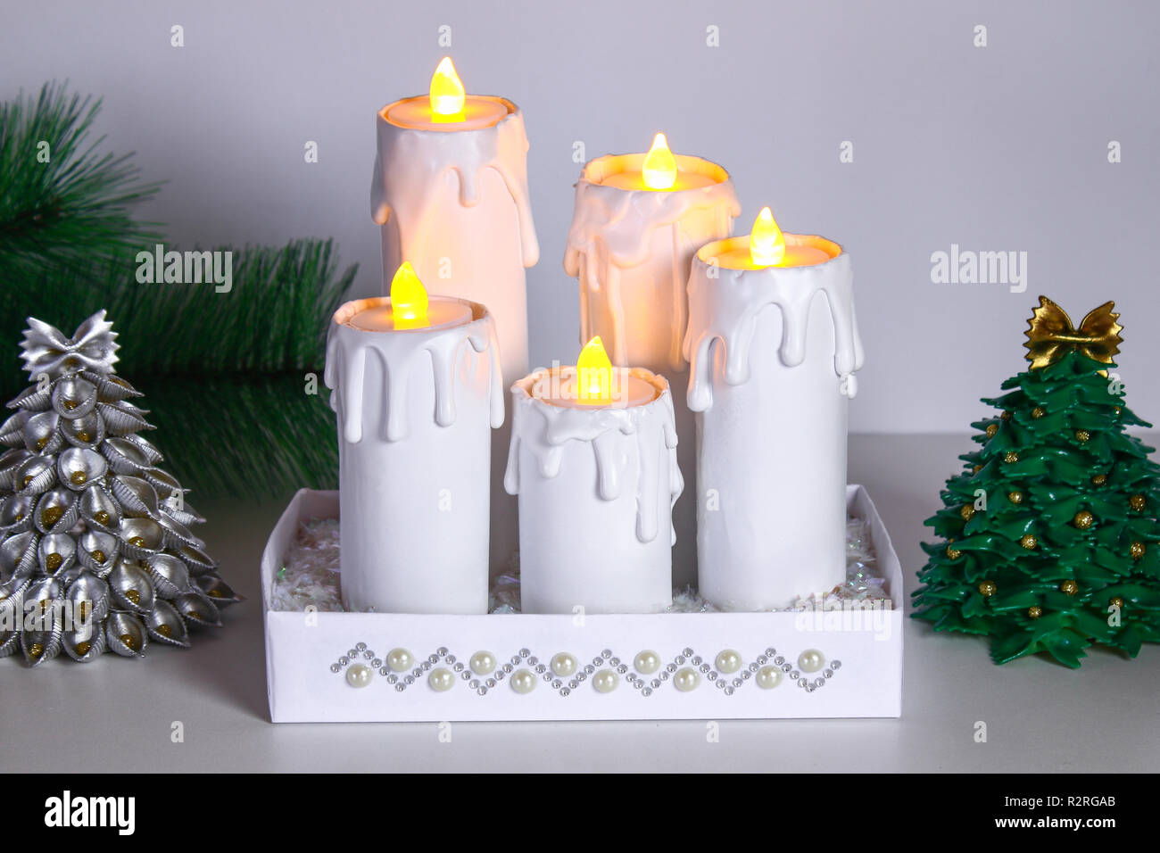 Cómo hacer velas de Navidad blanco tapones de rollos de papel higiénico,  pegamento caliente, pintura y velas. La creatividad de los niños. Bricolaje  de Navidad. Paso a paso en el p Fotografía