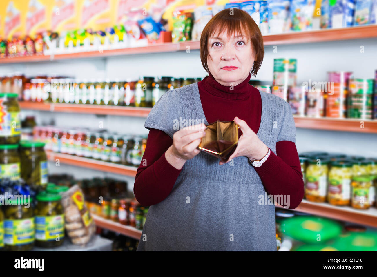 Ancianos malestar mujer con monedero del cliente sin dinero en la tienda de  comida Fotografía de stock - Alamy