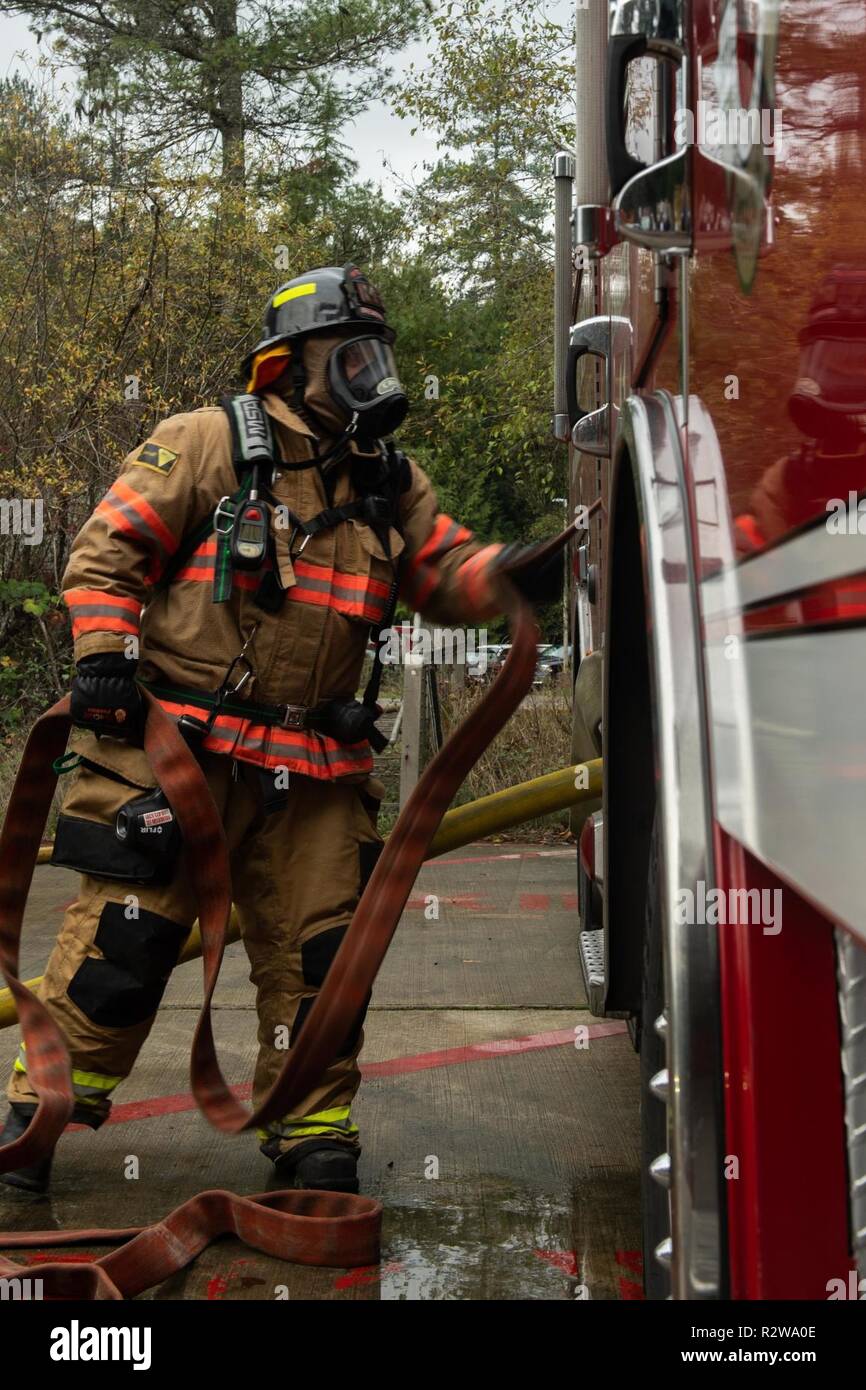 SILVERDALE, Washington (Nov. 15, 2018) un bombero para la Central de  Incendios y Rescate de Kitsap saca la manguera del motor 41 durante un  entrenamiento con fuego vivo común a bordo de