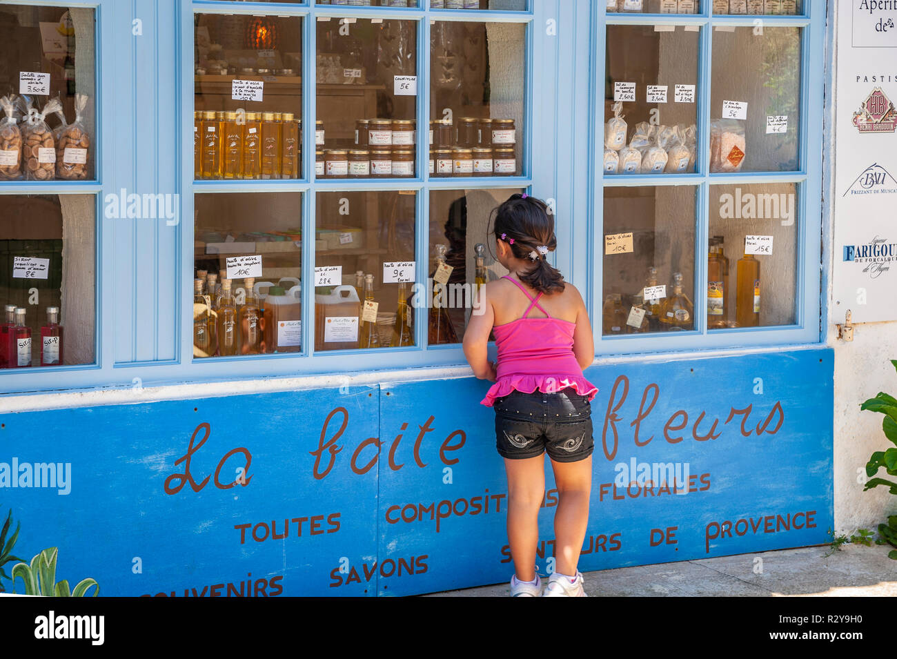 Muchacha en la ventana de una tienda de souvenirs, Ramatuelle, Var, Provence-Alpes-Côte d'Azur, Francia, Europa Foto de stock
