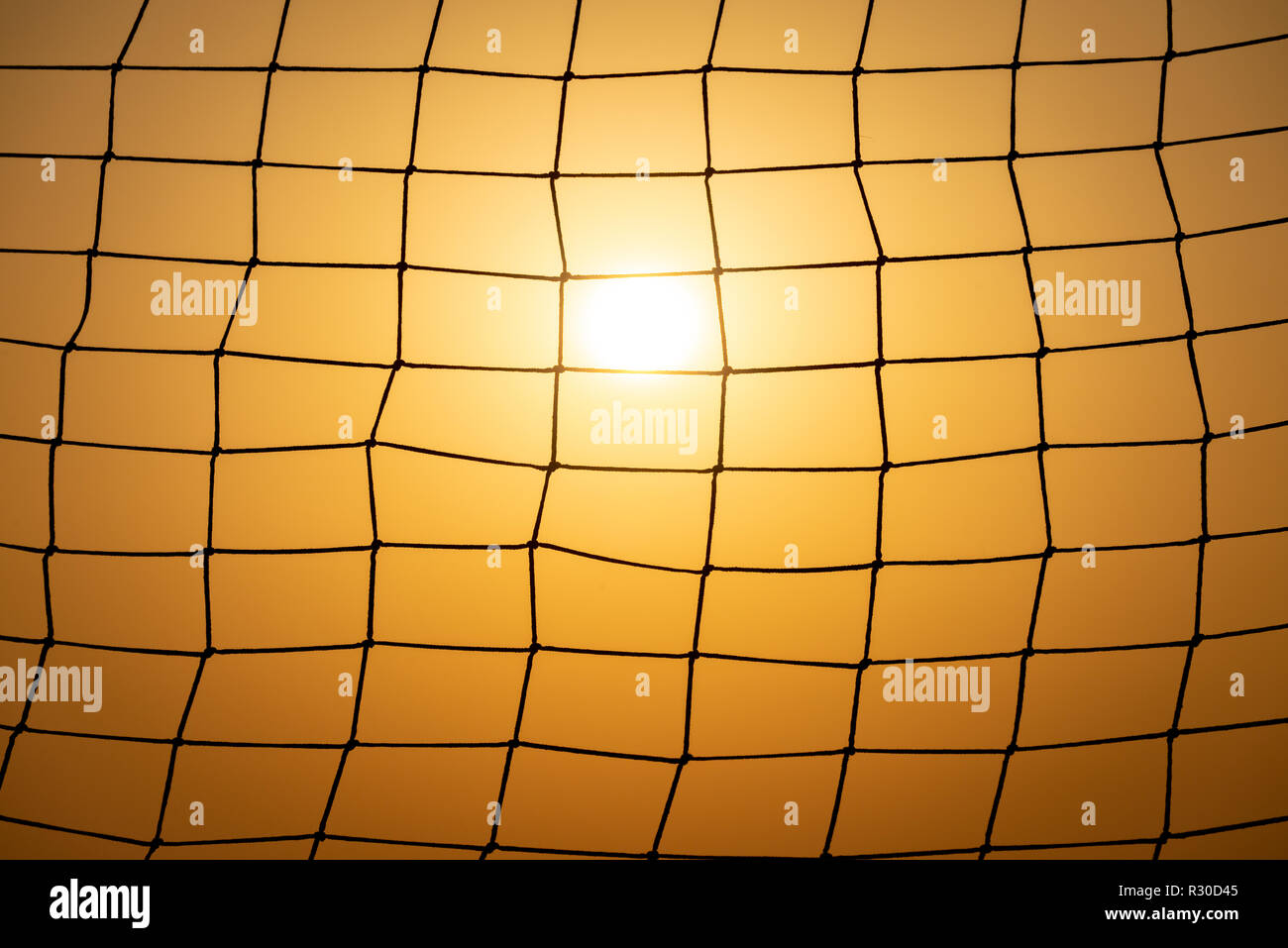 Objetivo de fútbol net al atardecer. Patrón de malla con sun y sunset sky en el fondo. Foto de stock