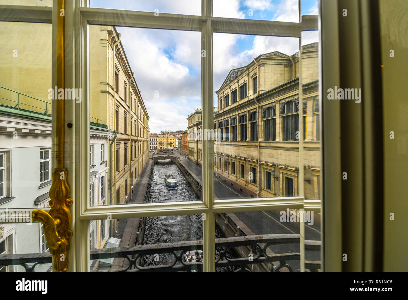 Un barco se desliza hacia abajo el invierno Kanavka Zimnyaya Canal y el río Neva en San Petersburgo, Rusia, vista desde una ventana de la galería en el interior de la Ermita Foto de stock