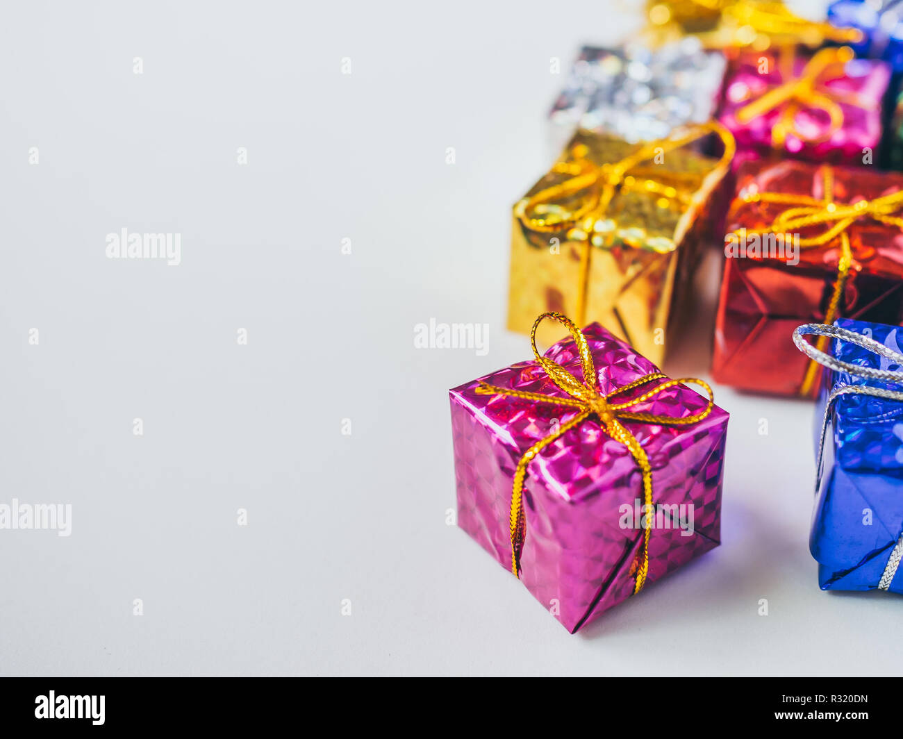 Pequeñas cajas de regalo de colores sobre fondo blanco con espacio de  copia. Vista superior de muchos regalos envueltos en papel brillante  colorido Fotografía de stock - Alamy