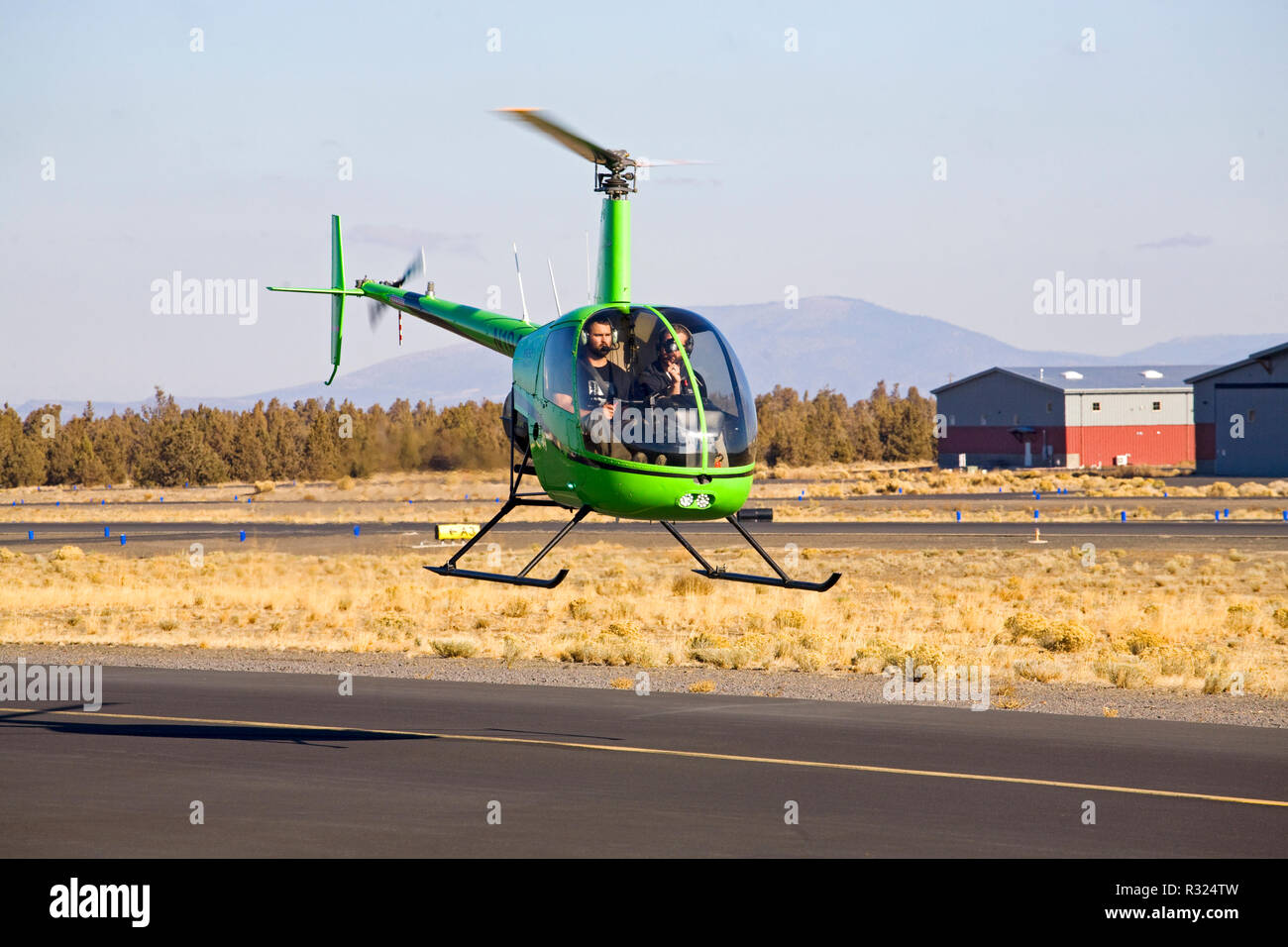 Un instructor y el estudiante volar un piloto de dos asientos de R22 Beta II hecha por el helicóptero Robinson Helicopter Company, en una pequeña ciudad aeropuerto en Bend, Oregon Foto de stock