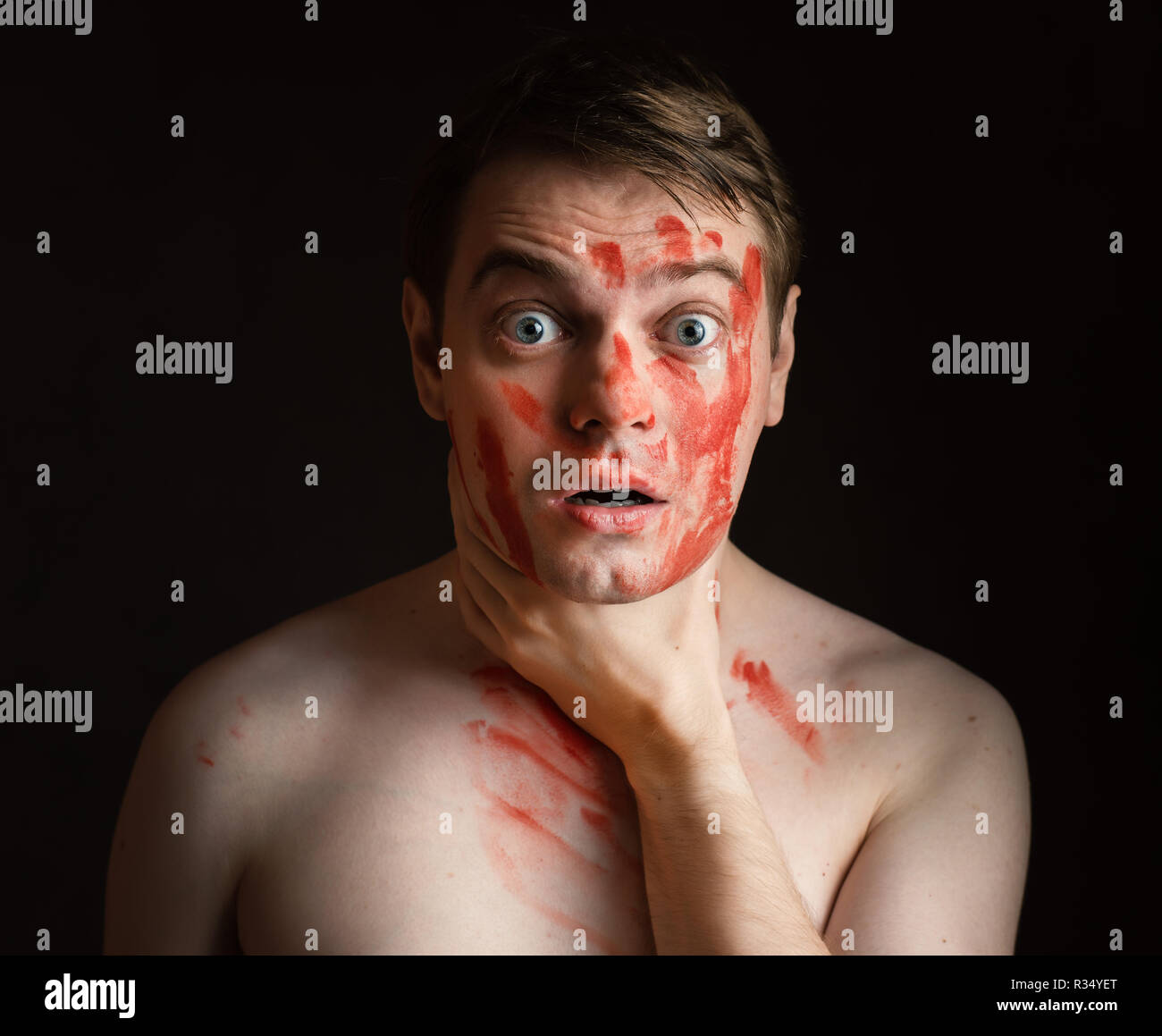 Joven con sangre en su rostro mantenga a sí mismo por el cuello. Foto de stock