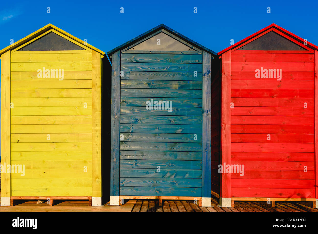 Cambiadores de cabañas para los bañistas en una playa del Mediterráneo en  verano, de color azul, amarillo y rojo Fotografía de stock - Alamy