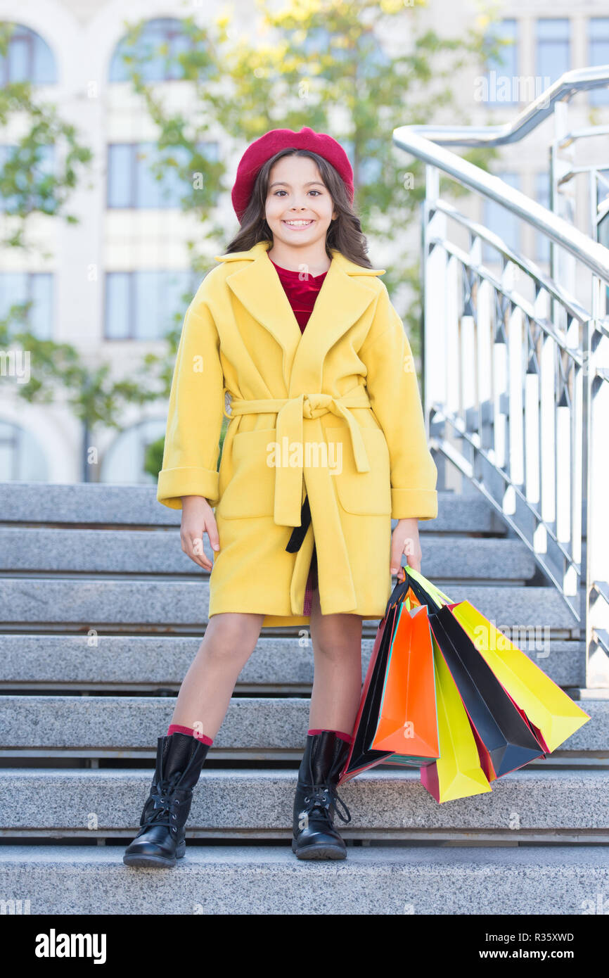 Cute Little Girl dama vestida en estilo francés abrigo y boina llevar bolsas  de la compra. Concepto de compras de otoño. Niño pequeño compras otoño  temporada de venta. Elegante y adorable hijo