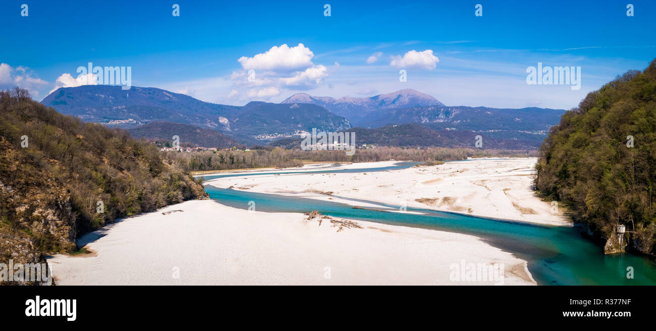 Río trenzada turquesa Tagliamente desde puente Pinzano con montañas, Cuel Flagjel di Forchia y Cuarón en el horizonte en la primavera en Italia Foto de stock