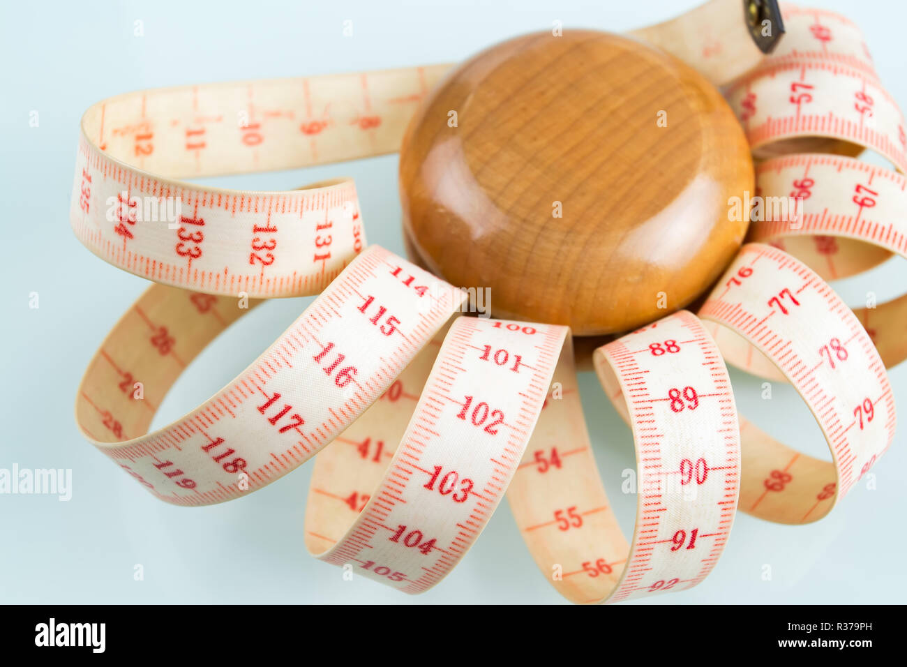 Efecto yo-yo en concepto de dieta. Yoyo de madera con medida de centímetro.  Fondo de cristal reflectante Fotografía de stock - Alamy