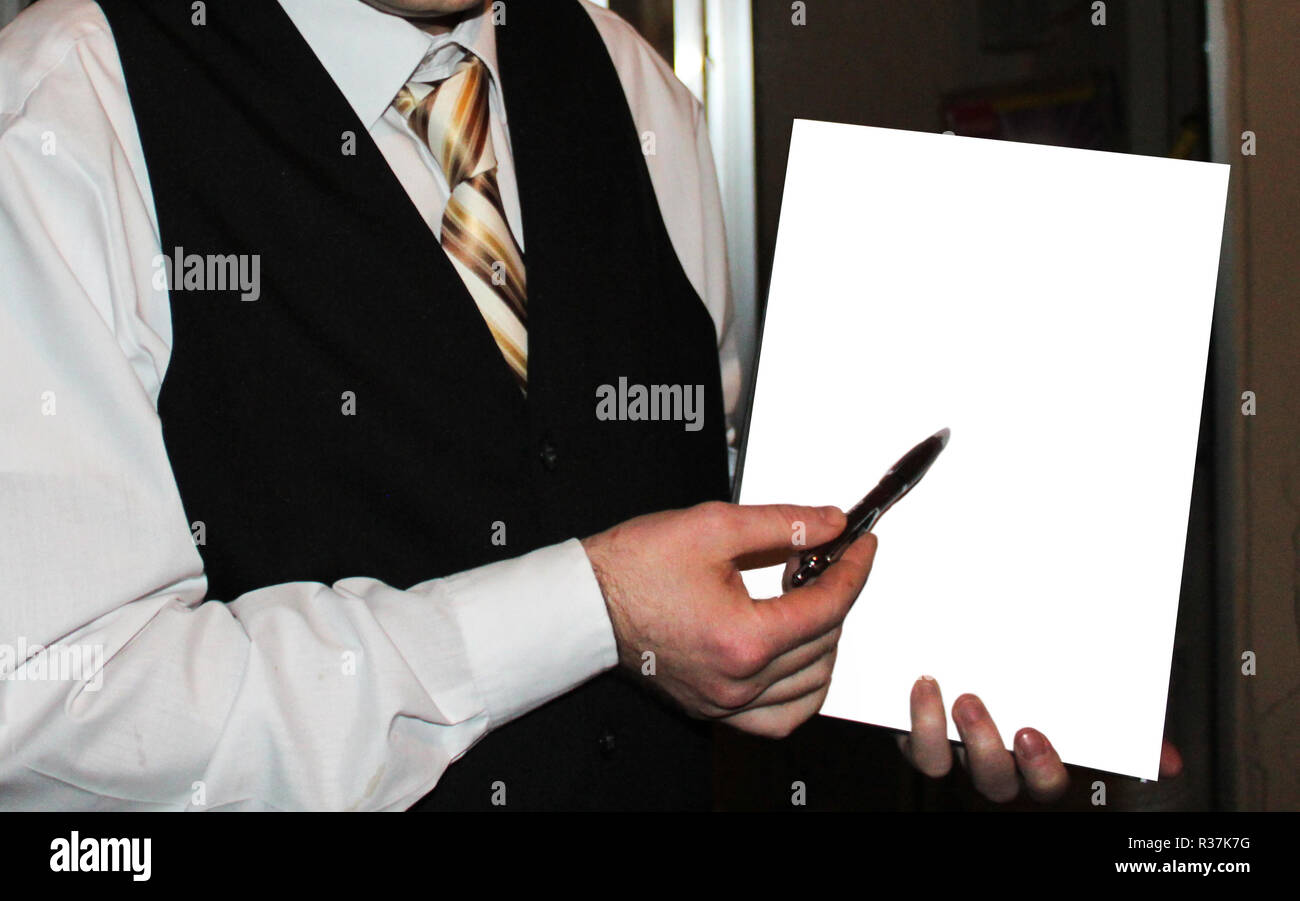 Hombre de la camisa blanca, chaleco negro y corbata de rayas doradas celebración libro blanco maqueta Fotografía de stock -