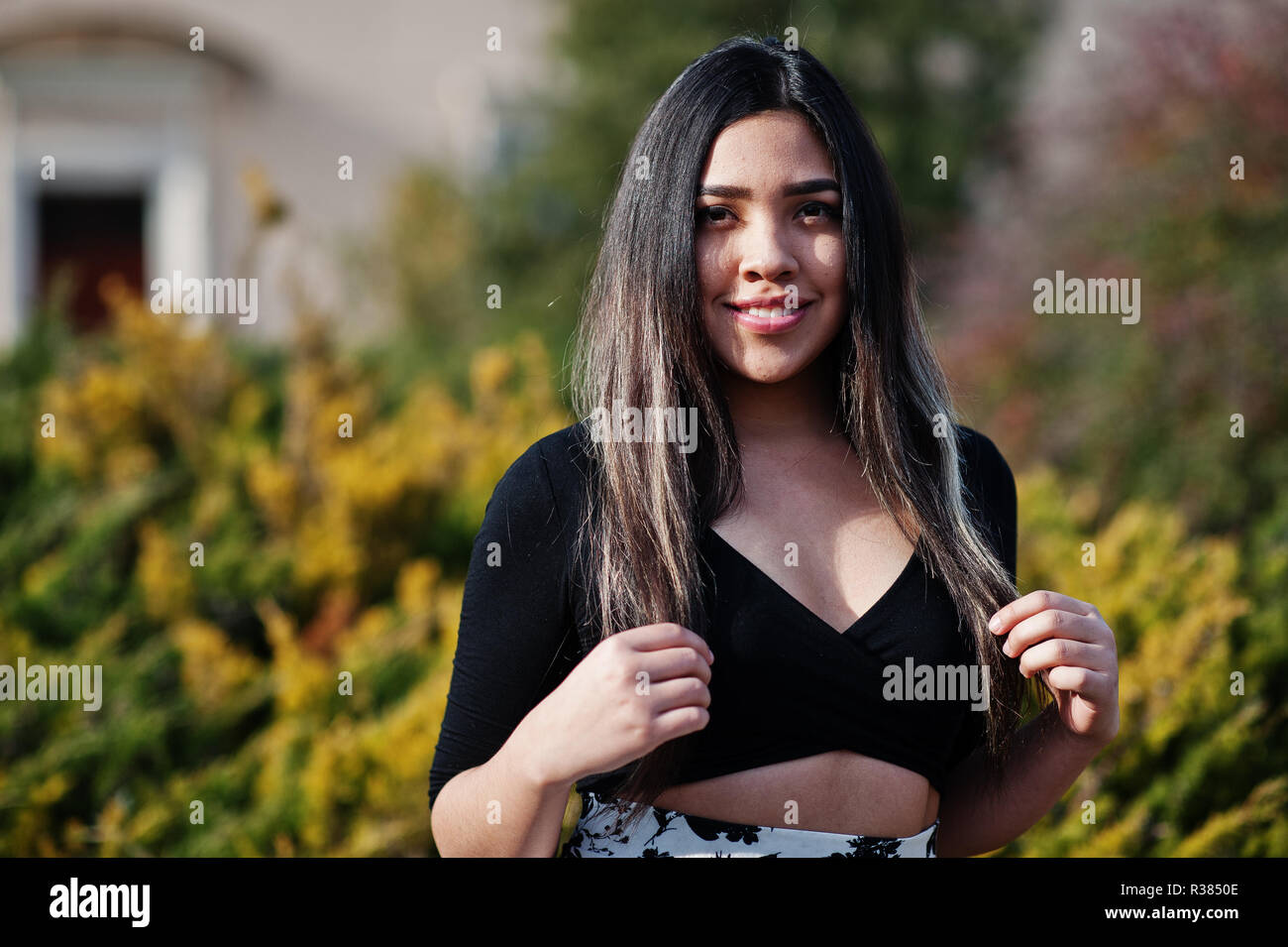 Bonita chica modelo latino de Ecuador desgaste en negro y falda de tops  planteados en la calle Fotografía de stock - Alamy