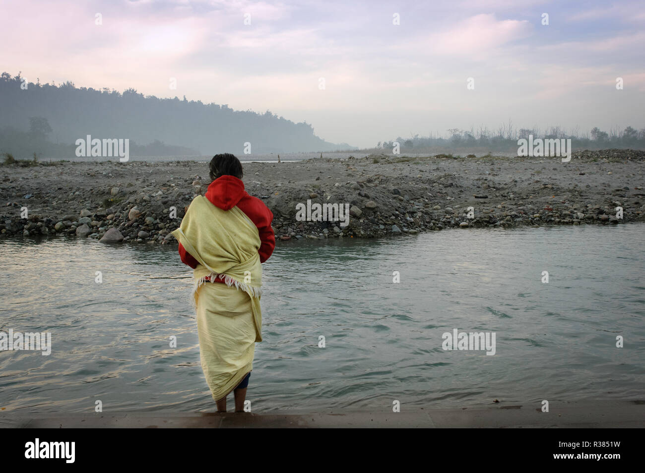 Un pelgrim meditando junto al río sagrado Ganges. Rishikesh, India Foto de stock