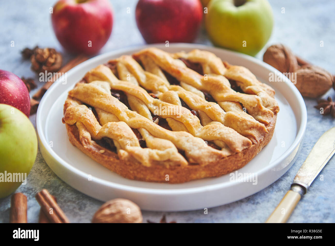 Tarta de manzana casera dulce sabroso pastel con palitos de canela, nueces y manzanas Foto de stock