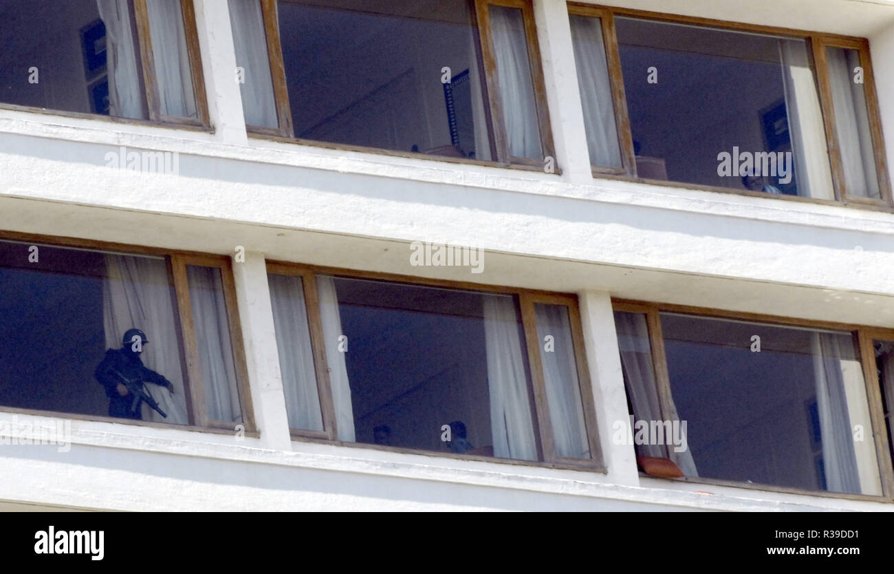 Guardia de Seguridad Nacional NSG commando abriendo la cortina para indicar la habitación está a salvo de Deccan Muyahidín terroristas en Oberoi Hotel Trident Nariman Point Mumbai, India el 27 /11/2008. Los terroristas mataron a 100 personas y más de 200 heridos en una serie de ataques coordinados a través de la India?s del centro financiero de Mumbai como pistoleros fuertemente armados en grupos de dos a cuatro abrieron fuego con armas automáticas y granadas lobbed en 10 lugares en el sur de Mumbai, incluidos los cinco estrellas hoteles Taj y Trident, la ciudad?s terminal principal de trenes, un hospital, una cafetería, un pub y una sala de cine. Foto: Dinodia (c) dpa - Report Foto de stock