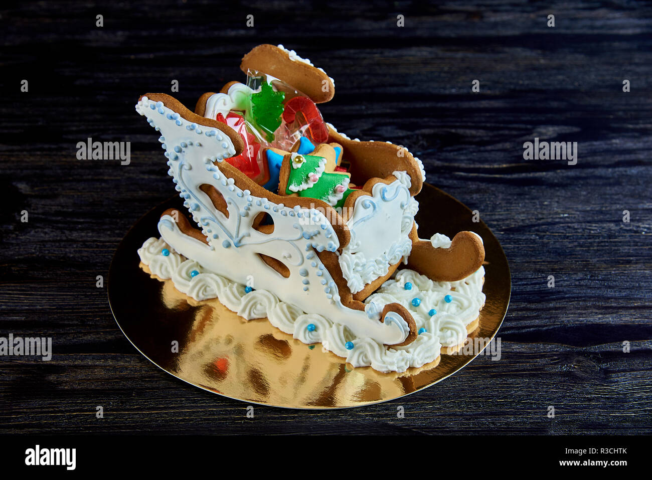 Gingerbread trineo con dulces de navidad sobre una superficie de madera oscura. Foto de stock