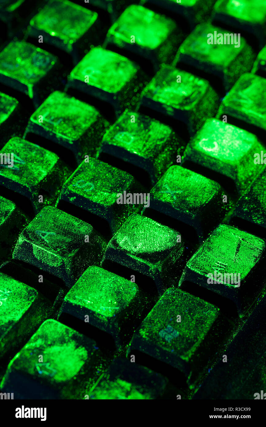 La ciencia forense, salpicaduras de huellas dactilares en el teclado del ordenador se muestran tras ser espolvoreado con pigmentos ultravioleta listo para resolver un crimen Foto de stock