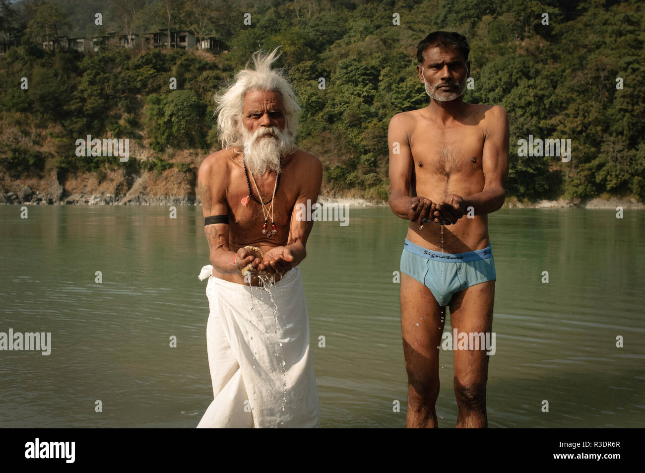 Sadhus tomando un baño en el río sagrado Ganges Foto de stock