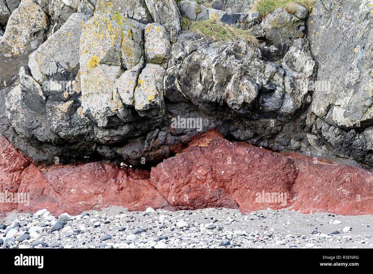 Estratos de roca basáltica downfaulted capas incluyendo rojo banda formada de las cenizas enterradas Ballintoy condado de Antrim de Irlanda del Norte Foto de stock