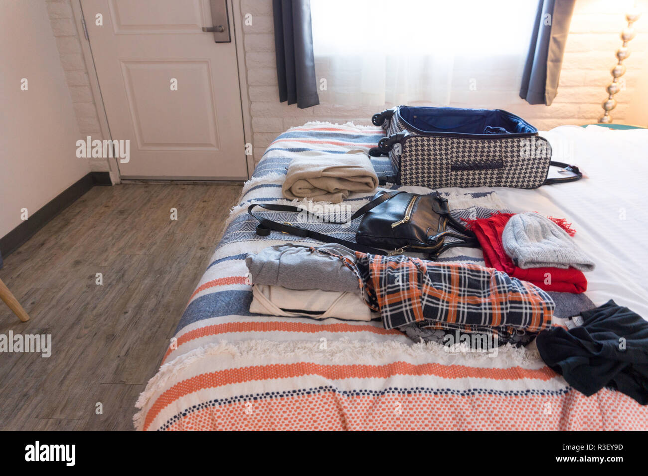 La ropa y la maleta sobre la cama en habitación de hotel hipster en USA -  empacando ropa de mujer Fotografía de stock - Alamy
