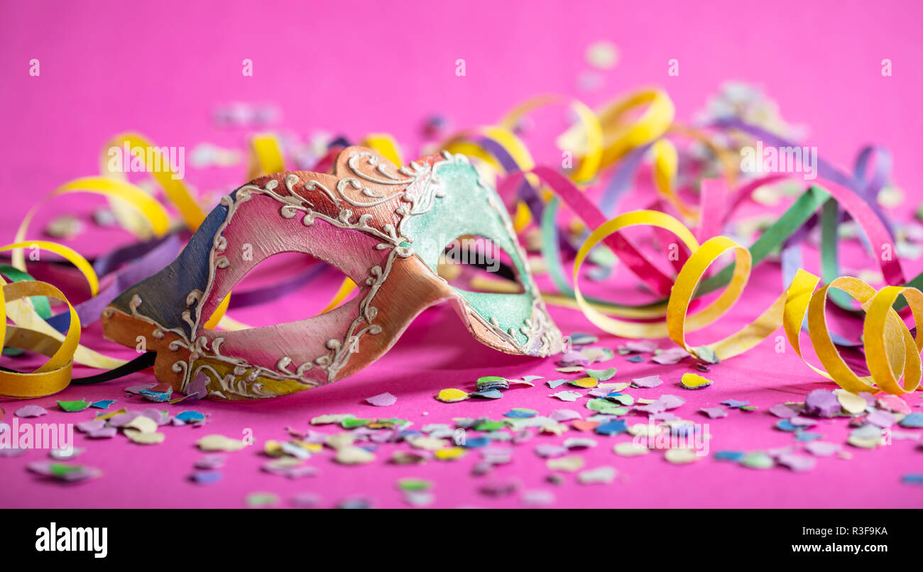 Fiesta de Carnaval. Máscara de colores, serpentinas y confeti sobre fondo  de color rosa brillante, banner Fotografía de stock - Alamy