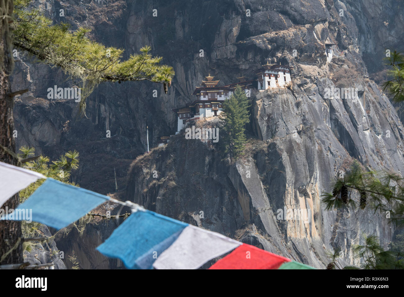 Bhután, Paro. Tiger's Nest (aka Paro Taktsang), prominente templo budista del Himalaya sagrado recinto con banderas de oración. Foto de stock