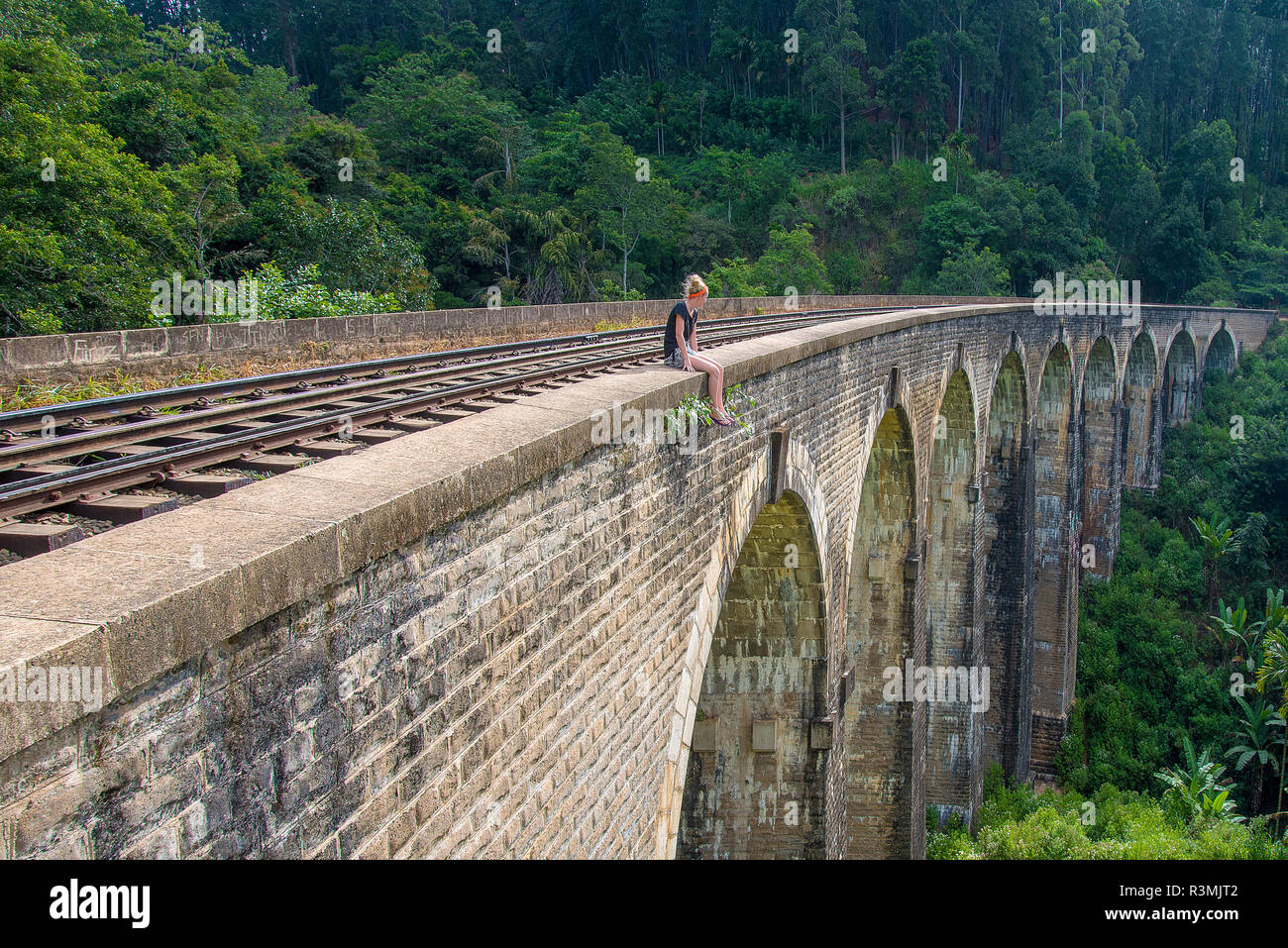 Una mujer joven admira la vista desde el puente de arco nueve en ella, Sri Lanka Foto de stock