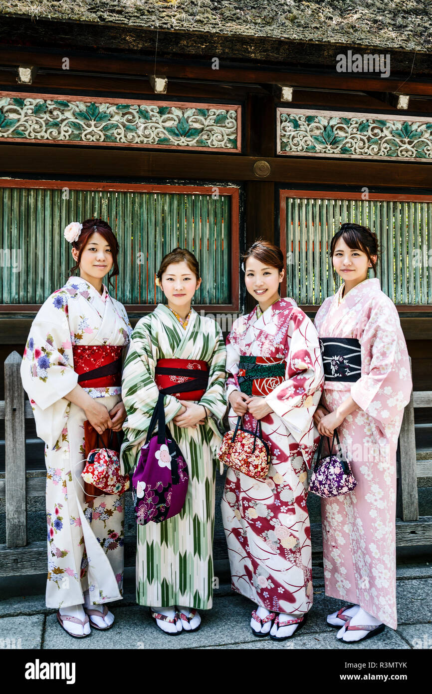 Kyoto, Japón. Cuatro jóvenes mujeres vestidas con kimono tradicional en el Shinto Yasaka-jinja, Gion Foto de stock