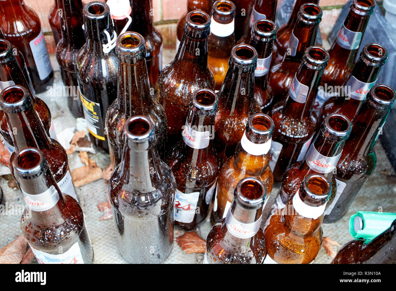 Las botellas de cerveza vacías deja sentados en la acera de una casa  Fotografía de stock - Alamy