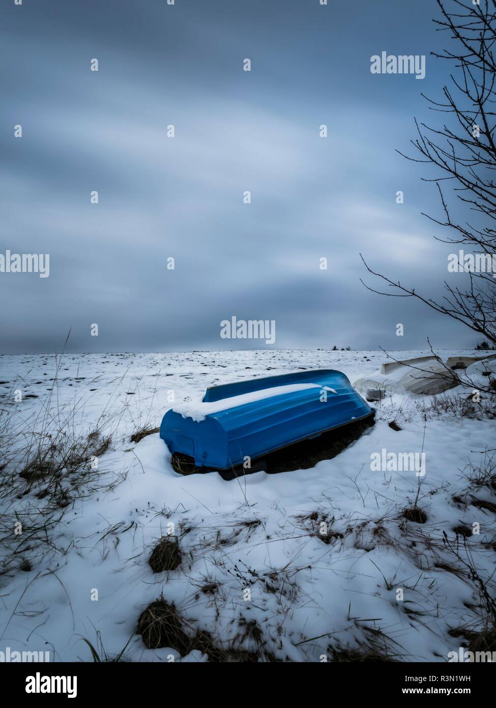 La larga exposición a principios del invierno la nieve en Europa Croacia Lokve destino lacustre barco azul mintiendo ahore invertida Foto de stock