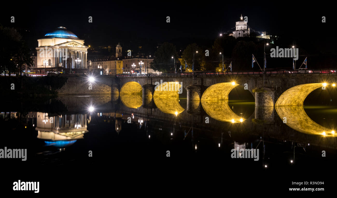 Ponte Umberto I, puente sobre el río Po, en el centro de Turín, Italia. La Iglesia de la Gran Madre puede verse sobre el puente. Fotografiado en la noche. Foto de stock