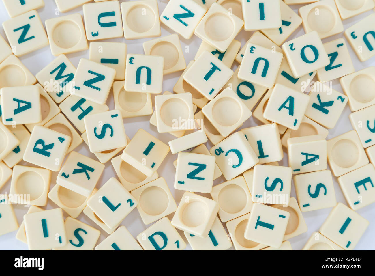 Montón de Scrabble aleatorio carta de azulejos con valor de puntuación mezclados antecedentes, visto desde arriba. Foto de stock