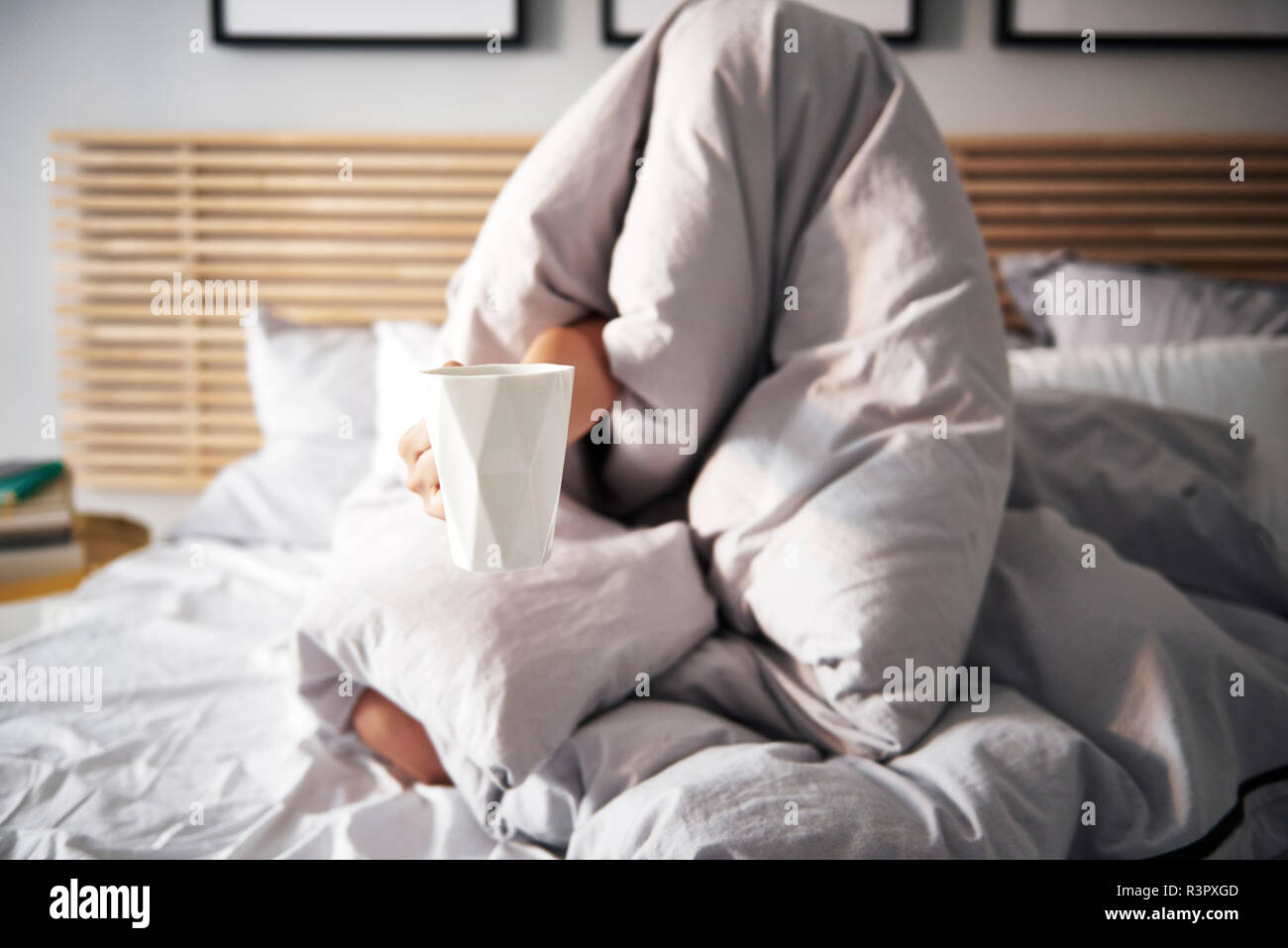 Mujer oculto bajo una manta café exigentes Foto de stock