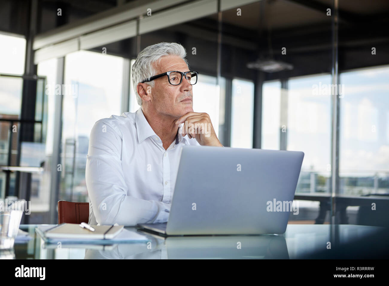 Hombre de negocios sentado en la oficina, pensando Foto de stock