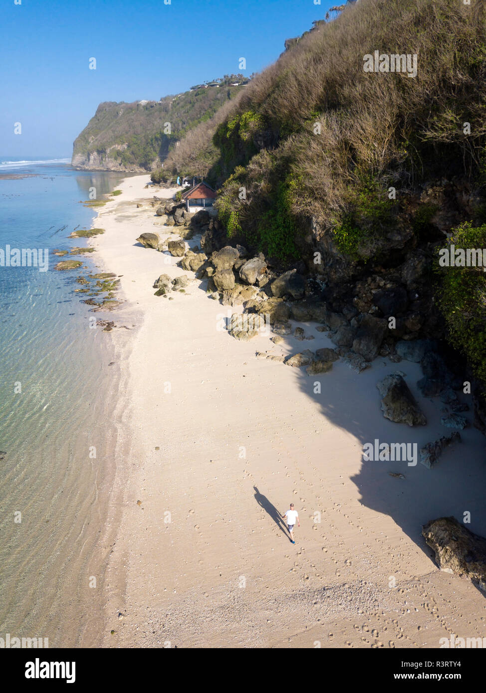 Indonesia, Bali, vista aérea del Karma Kandara playa, hombre que camina en la playa Foto de stock