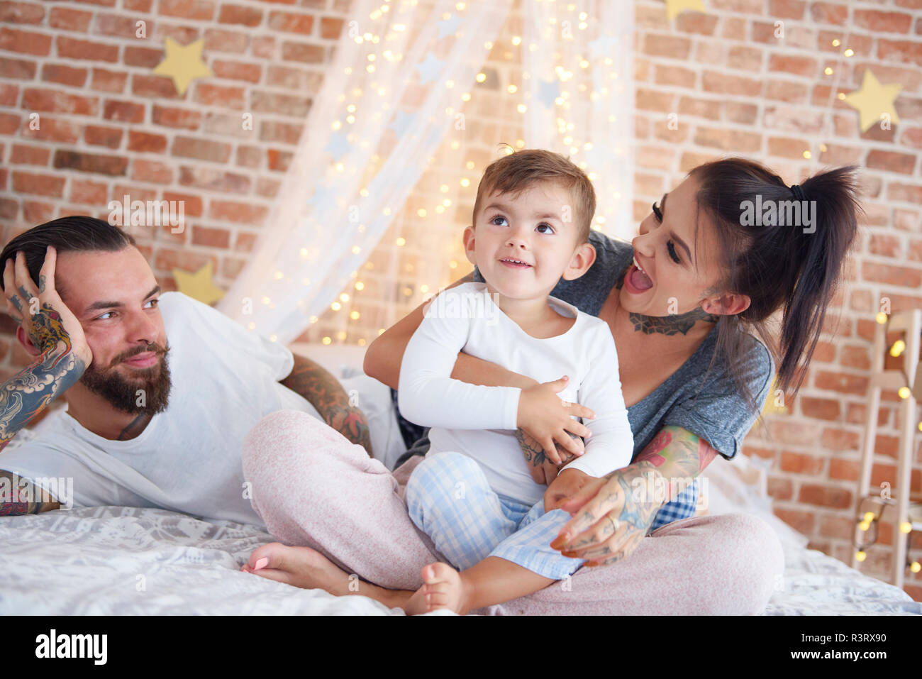 Familia Feliz en el tiempo de Navidad en la cama Foto de stock