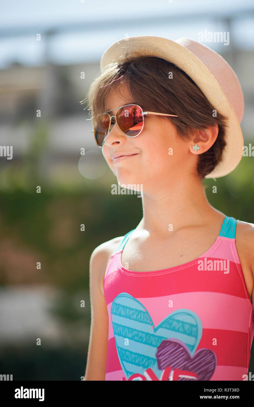 Retrato de joven con gafas de sol y sombrero para el sol, mirando hacia los lados Foto de stock