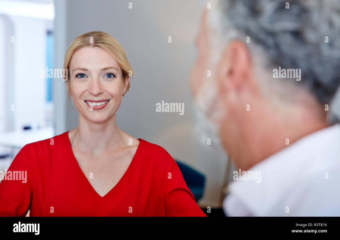 Retrato de mujer sonriente con colega maduro en Office Foto de stock