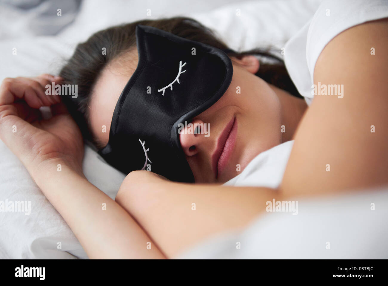 Retrato de mujer joven con máscara de reposo en la cama Foto de stock