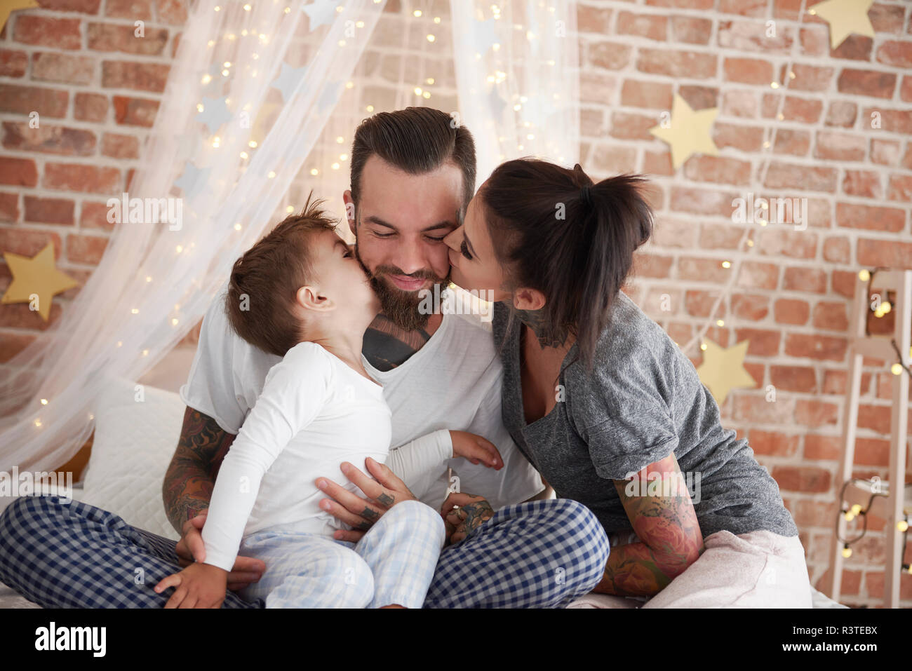 Familia Feliz en el tiempo de Navidad en la cama Foto de stock