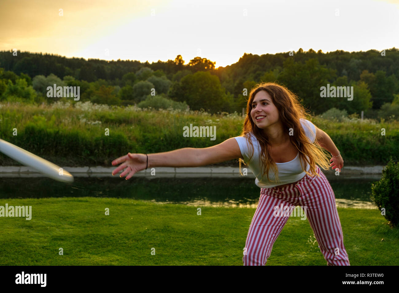 Mujer joven arrojando flying disc Foto de stock