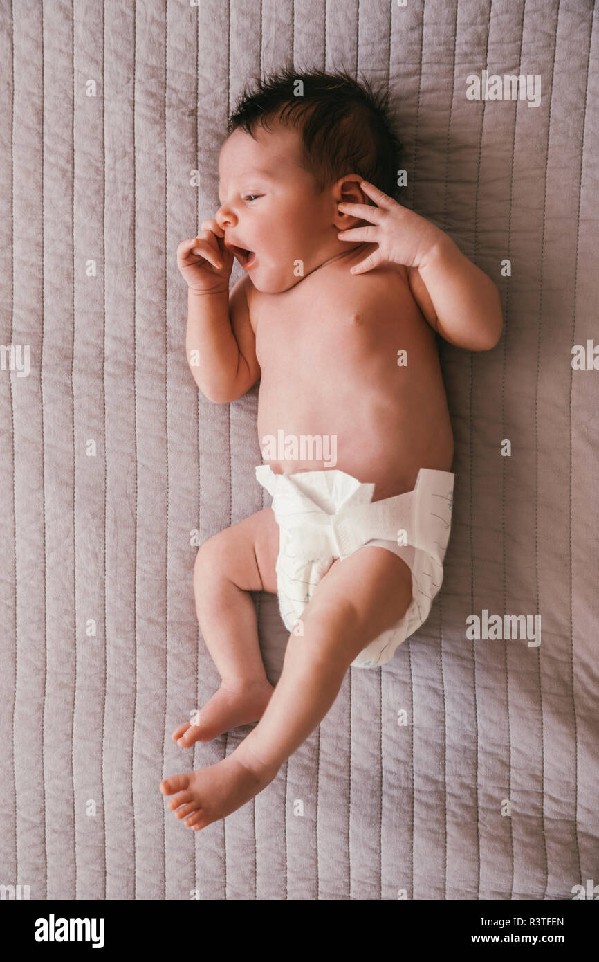 Bebé recién nacido niño en pañales acostado sobre una manta