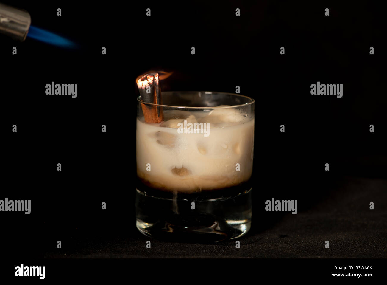 Flaming Canela cóctel con crema irlandesa baileys kahlua, y sambuca con fondo negro aislado Foto de stock