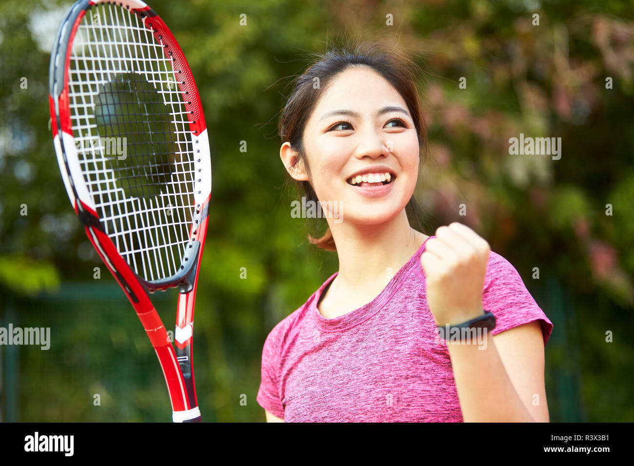 Outdoor retrato de una mujer asiática feliz jugador de tenis femenino Foto de stock