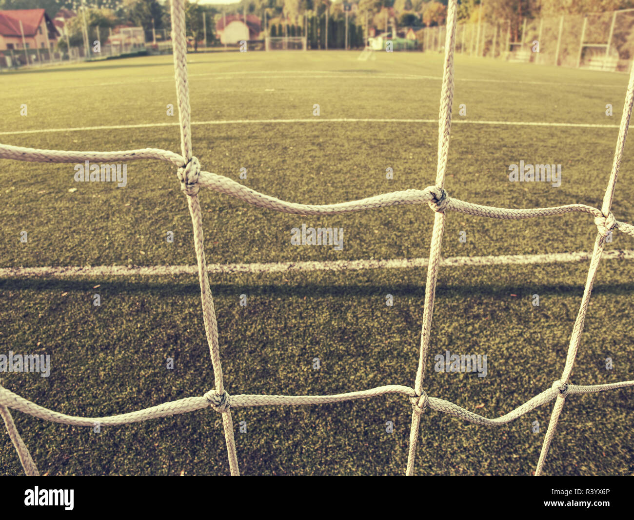 Esquina de fútbol soccer o líneas a través de la red de seguridad. Vista desde detrás de la Tribune net con estadio borrosa y tono de campo Foto de stock