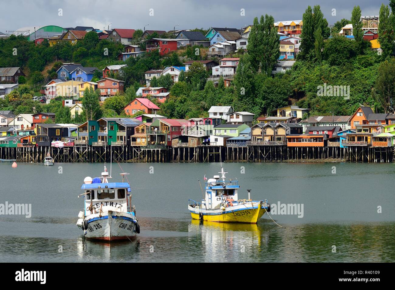Anclaje de botes de pesca en frente de coloridos palafitos, amontonan viviendas, llamadas palafitos, Castro, isla de Chiloé, Chile Foto de stock