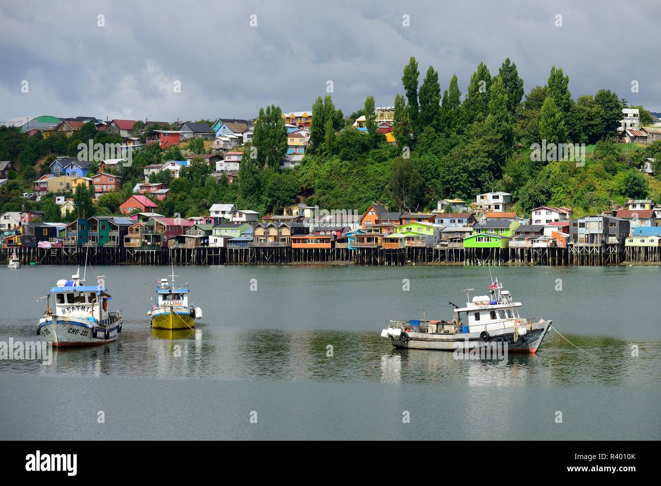 Anclaje de botes de pesca en frente de coloridos palafitos, amontonan viviendas, llamadas palafitos, Castro, isla de Chiloé, Chile Foto de stock