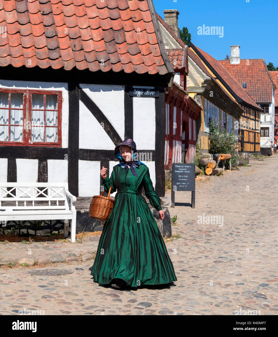 Mujer vestida con trajes de época en el casco antiguo de la ciudad (Den Gamle By), un museo al aire libre en Aarhus, Dinamarca Foto de stock