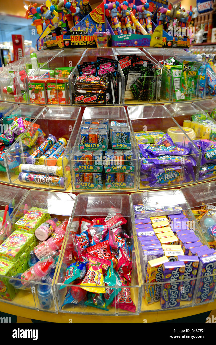 Un gran surtido de dulces, organizado en compartimentos en los estantes de una tienda de caramelos. Foto de stock