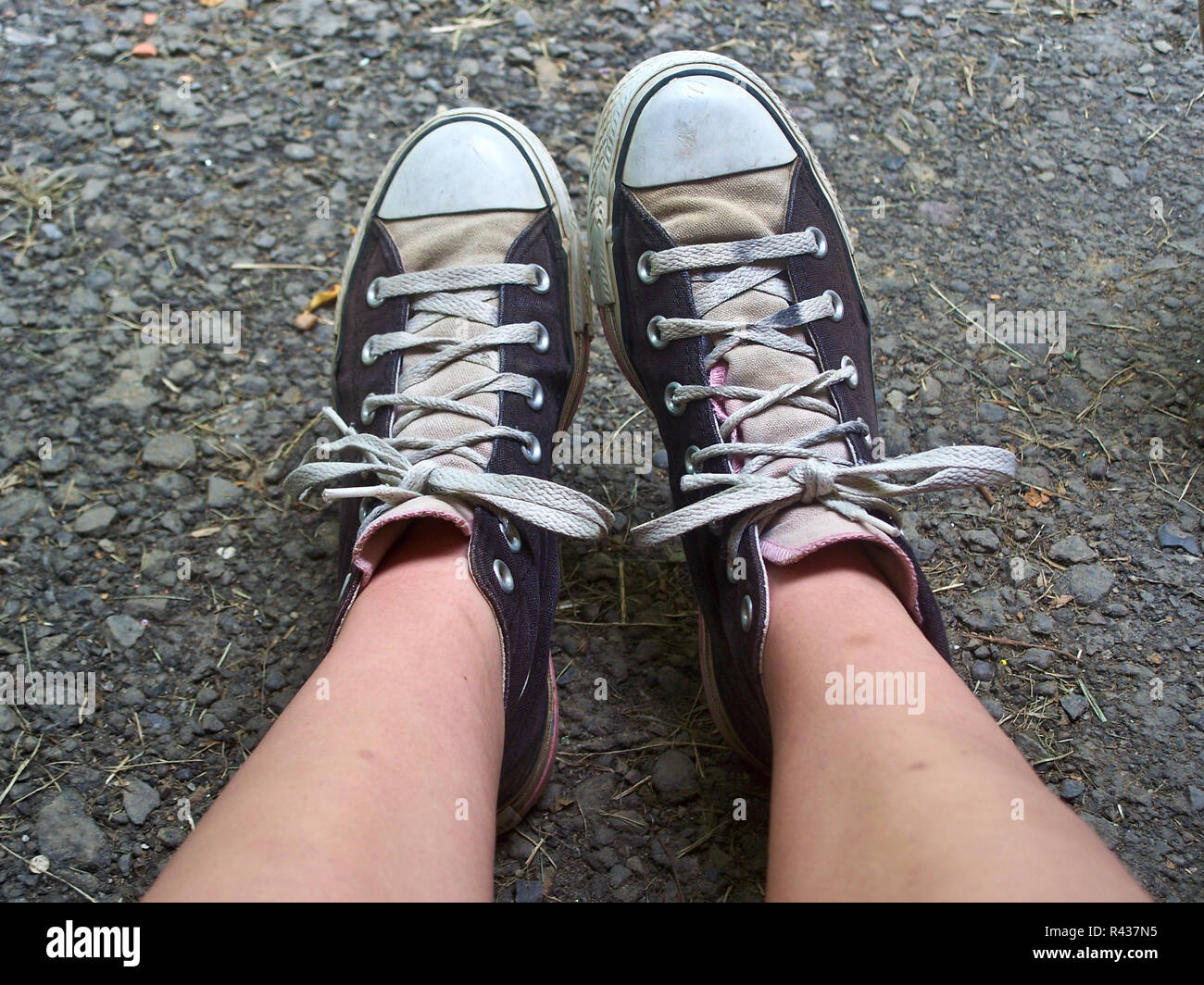 Una jovencita de pies y piernas, vistiendo Chuck Taylor high top Converse  zapatos de tenis Fotografía de stock - Alamy